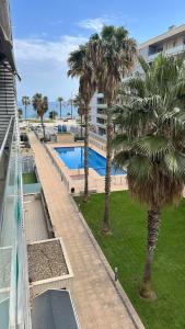 a balcony of a building with palm trees and a swimming pool at Apt compartido martirrena in Badalona