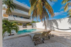 a house on the beach with two chairs and a swimming pool at Departamento de playa con Alberca in Telchac Puerto