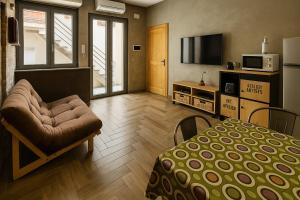 a room with a bed and a chair and a television at Mondello's Pearl in Mondello