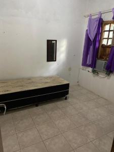 a bedroom with a bed in a room with purple curtains at Casa de praia com piscina in Cabo de Santo Agostinho