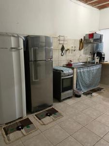 a kitchen with a stainless steel refrigerator and a stove at Casa de praia com piscina in Cabo de Santo Agostinho +4 photos