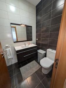a bathroom with a toilet and a sink and a mirror at Apartamento Sol e Mar in Fão +19 photos