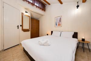 Un dormitorio con una gran cama blanca y una mesa. en Cozy Nest Charming Loft in the heart of Varna, en Varna