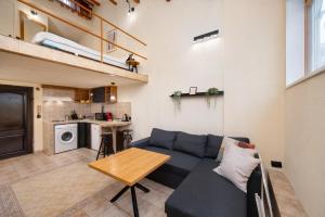 una sala de estar con un sofá y una mesa en Cozy Nest Charming Loft in the heart of Varna, en Varna