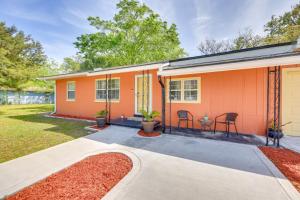a orange house with two chairs and a patio at 2 Mi to Dtwn Home with Game Room in St Augustine! in Saint Augustine