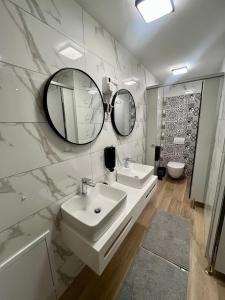 un bagno con lavandino e due specchi sul muro di Apartman Kupa a Žakanje Altre 28 foto