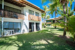 a view of the courtyard of a resort with palm trees at Lindo Apto em Cond. c/ Piscina no Litoral CQS0004 in Itacimirim