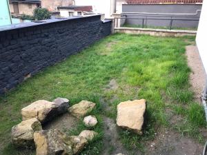 a yard with some rocks in the grass at Suterénní byt na Hejtmánce v Mladé Boleslavi u letiště in Mladá Boleslav