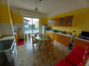 una cocina con mesa y sillas y una cocina con paredes amarillas. en VillAlbero B&B, en Inveruno
