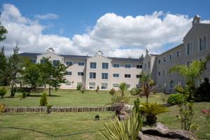 a large apartment building with a lawn in front of it at Howard Johnson Plaza & Convention Center Spa La Plata in La Plata