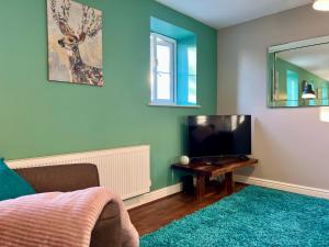 ein Schlafzimmer mit einem Bett, einem Fernseher und einem Spiegel in der Unterkunft The Orchid-Central Beeston-Private Apartment-SmartTV-Free Wi-Fi-Tram-Parking in Nottingham