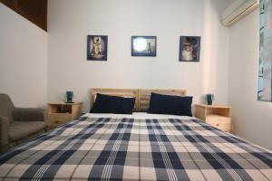 a bedroom with a blue and white checkered bed at B&B Santiago in Gela