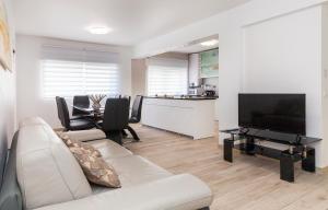 Una sala de estar con un sofá, un televisor y una mesa. en The Chairs Place GuestHouse, en Lagos