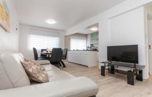 Una sala de estar con un sofá, un televisor y una mesa. en The Chairs Place GuestHouse, en Lagos