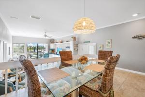 a dining room with a glass table and chairs at Lake House at the Beach C207 by Beachside Management in Siesta Key