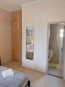 a bedroom with a mirror and a bed and a shower at Pefkos Beach House 2 in Kámpos +23 photos