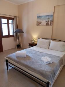a bedroom with a large bed with two towels on it at Pefkos Beach House 2 in Kámpos