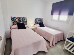 Habitación con 2 camas y sábanas rosas. en Casa Calma, en Conil de la Frontera 23 fotos más