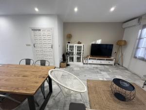 een woonkamer met een tafel en een flatscreen-tv bij Moderno dúplex Coastal Style in Playas de Vera