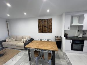 een keuken en woonkamer met een tafel en een bank bij Moderno dúplex Coastal Style in Playas de Vera +52 foto's
