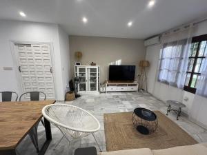 een woonkamer met een televisie en een tafel en stoelen bij Moderno dúplex Coastal Style in Playas de Vera