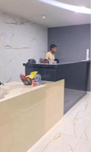 un homme debout à un comptoir dans un bureau dans l'établissement Hotel Siga, à Ribas do Rio Pardo