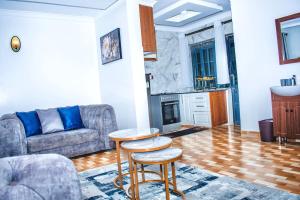 a living room with a couch and a table at Cool Breeze Penthouse - Nati Apartment in Kisumu