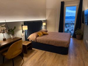 a bedroom with a bed and a desk and a window at 88 Miglia in La Spezia