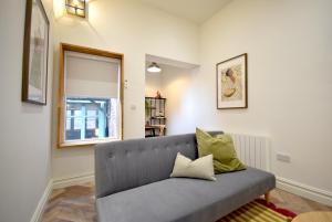 a living room with a gray couch and a window at CITYeSCAPE - Spacious 1BR Duplex Sofabed - NQ in Manchester +8 photos