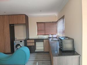 eine Küche mit blauem Sofa in einem Zimmer in der Unterkunft Bachelor cottage on an estate in Eikenhof