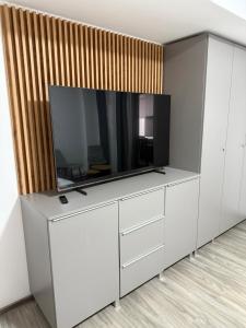 una sala de estar con TV en un centro de entretenimiento blanco en Brâncoveanu, en Craiova