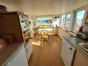 a kitchen and dining room with a table and chairs at Taigh Nandag in Valtos