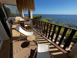 a balcony with a table and chairs and the ocean at Beautiful beachfront apartment in Carry-le-Rouet