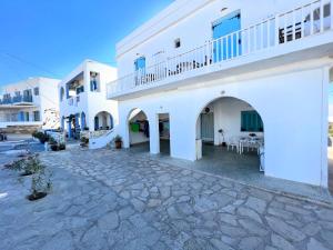 a large white building with a stone courtyard at Windmill Rooms in Antiparos