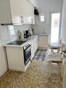 a kitchen with white cabinets and a table in it at Windmill Rooms in Antiparos