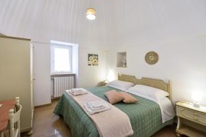 a bedroom with a green bed with two towels on it at La Dimora di Peppe in Locorotondo
