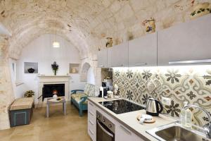 a kitchen with a living room with a fireplace at La Dimora di Peppe in Locorotondo +11 photos