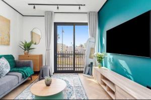 a living room with a couch and a flat screen tv at Luxe at Nine Palms Near Canal Walk in Cape Town