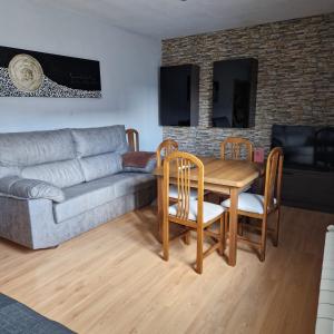 a living room with a couch and a table with chairs at Piso de La Luna in Cazorla