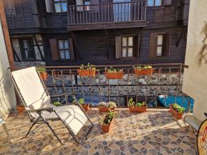 a chair sitting on a patio with potted plants at Apartament Magi in Sozopol +6 photos