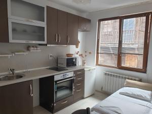 a small kitchen with a sink and a microwave at Apartament Magi in Sozopol