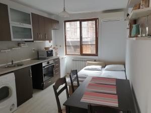 a small kitchen with a table and a dining room at Apartament Magi in Sozopol