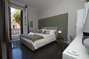 ein Schlafzimmer mit einem Bett und einem großen Fenster in der Unterkunft La finestra sul Campanile Luxury Suite & Loft in Bari + 35 Fotos