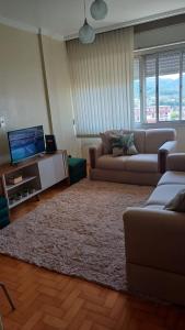 a living room with two couches and a television at Apartamento com linda vista in Santa Maria