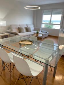 a glass table and chairs in a living room at Apartamento Garnacha Rioja Aire Acondicionado,Wifi,BUS Búho in Lardero