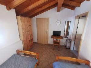 a room with two beds and a desk with a computer at La Pagliera in Miglieglia