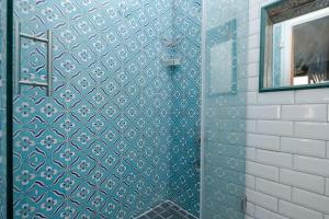 a bathroom with a blue tiled shower with a mirror at Exclusive House with 2 Apartments including 4 Bedrooms and 4 Bathrooms in Total in Istanbul