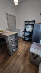a kitchen with a counter and a table and a refrigerator at Apartment A&D Home Imola Centro in Imola
