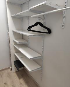 a walk in closet with white shelves at Kobal Apart in Bolesławiec