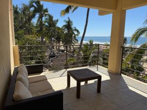 a balcony with a couch and a table and the ocean at SeArena San Pancho in San Francisco